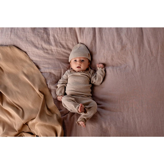 Baby in beiger Tub Legging mit passendem Strick-Outfit für stilvolle Kleinkinder