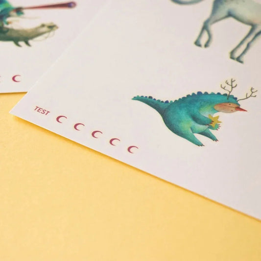 Teal cartoon dinosaur with a branch on its back featured in Unicorn Tattoos