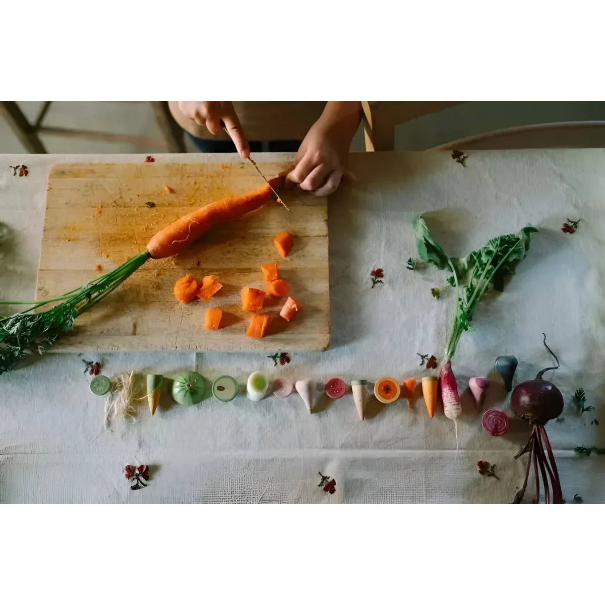 Ein lebendiger oranger karotte mit grünem blattwerk wird auf einem holzschneidebrett in veggies geschnitten