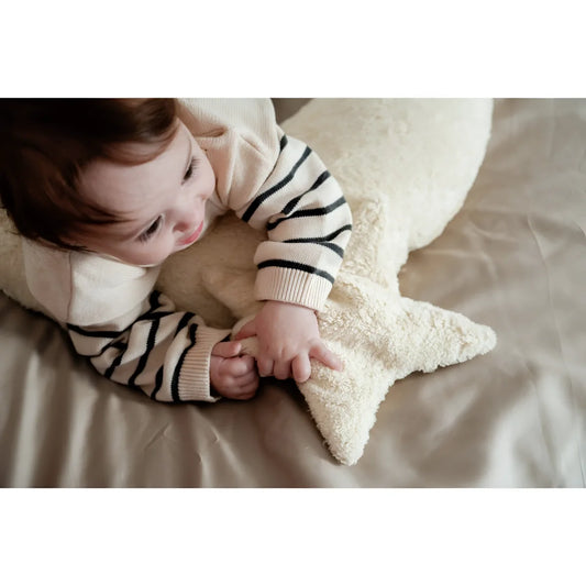 Baby umarmt ein Wärmekissen Stern in Vanillefarbe