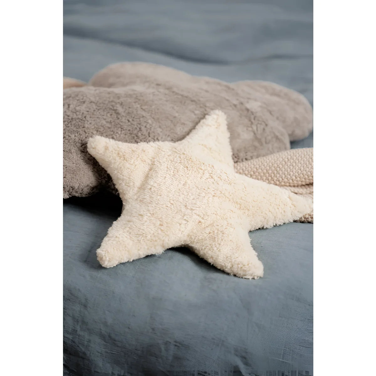 Helle, flauschige Stern-Kissen in Vanille für Wärme und Gemütlichkeit