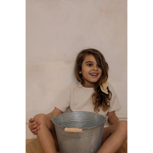 Junge Frau sitzt mit einem Metall-Eimer zwischen den Beinen im Waffle Boxy T-Shirt