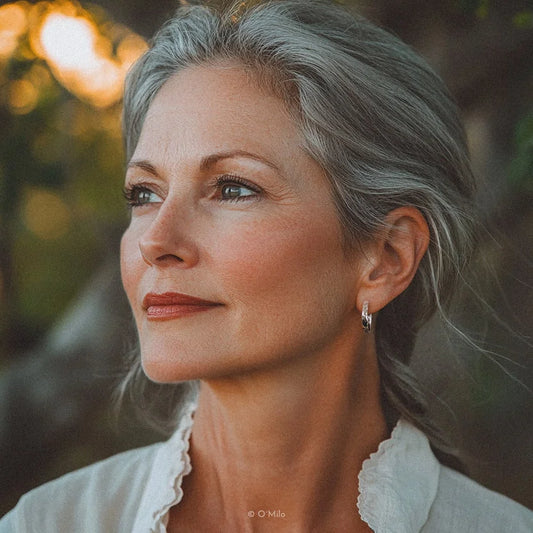 Hand hält texturierte Silber-Odelia-Kreolen mit hammerter Oberfläche