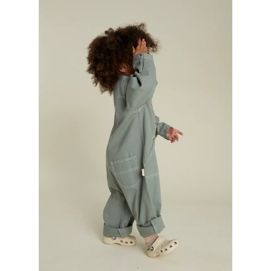 Kind eines Kindes in einem grünen Overall und Crocs für Western Overall Seagreen