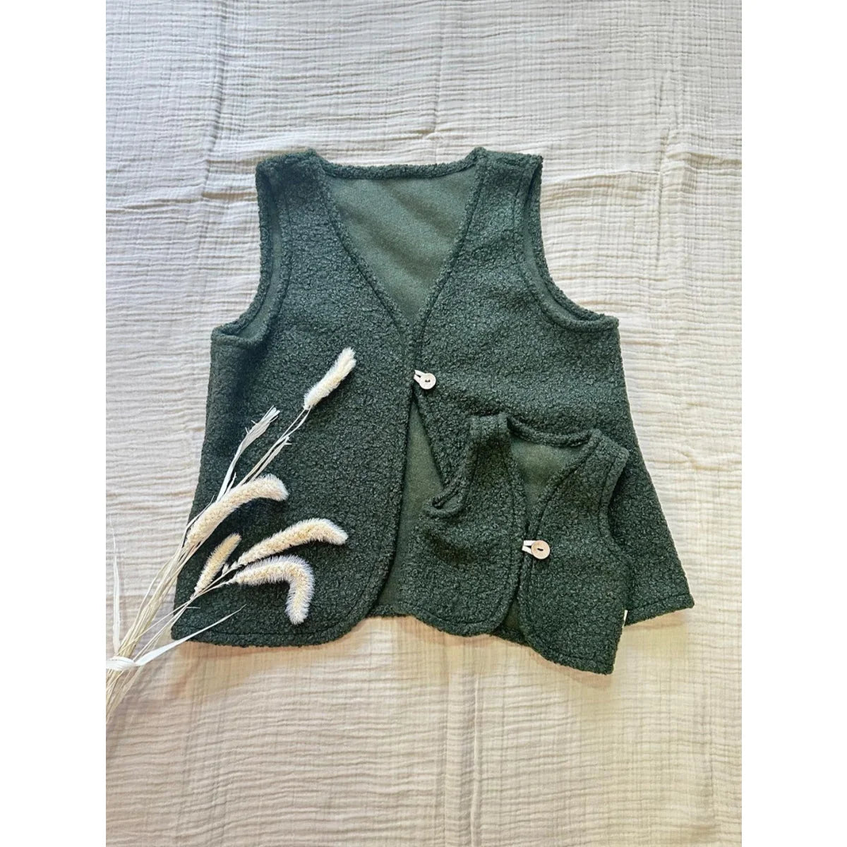 Dunkelgrüne strukturierte Weste für Erwachsene und Kind mit heller Knopfleiste