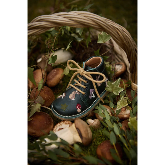 Dunkelgrüner Leder-Kinderschuh mit hellbraunen Schnürsenkeln und Naturmotiven
