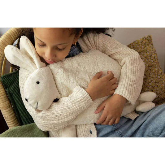 Mädchen umarmt einen Plüschhasen aus Zirbenkissen Hase für zusätzlichen Komfort