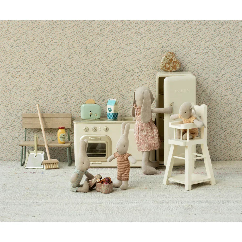 Wunderliche Hasenfamilie spielt mit Miniaturküchengeräten und Möbeln