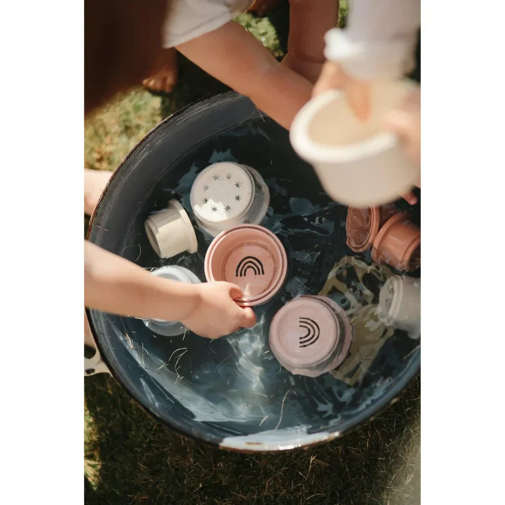 Hände waschen Geschirr in einer dunkelblauen Spüle, MUSHIE Kollektion bei Littlies.