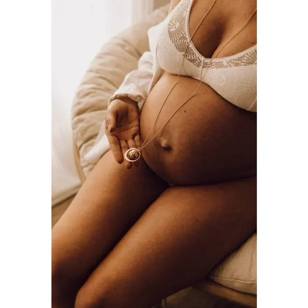 Schwangere Bauch mit Ehering, symbolisierend Liebe und neue Anfänge.