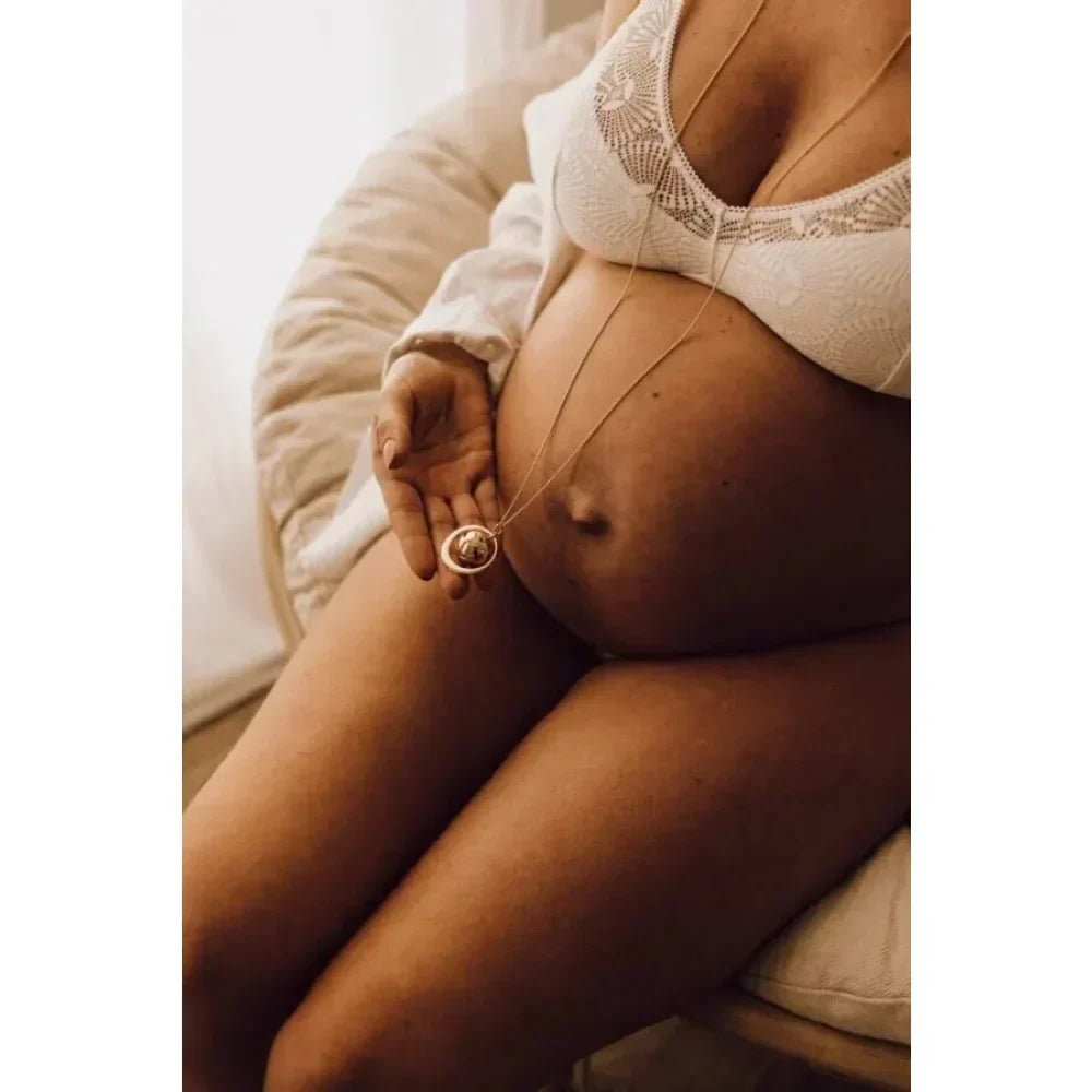 Schwangere Bauch mit Ehering, symbolisierend Liebe und neue Anfänge.