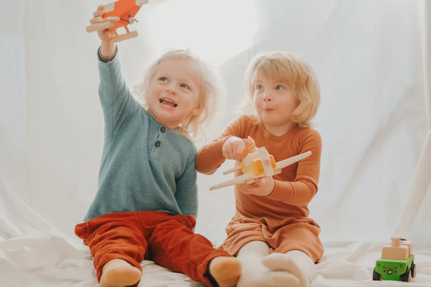 Zwei junge Kinder spielen mit Holzspielzeug in der HOLLER POLLER Kollektion