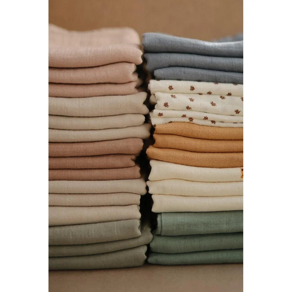 Neatly folded stacks of Mulltuch in muted colors from the Rainbows collection