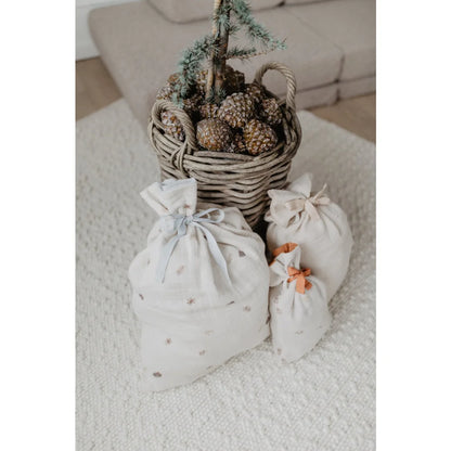 Woven basket mit Pinecones und kleinen Tannenbaum, umgeben von 3 Musselin Geschenksäcken