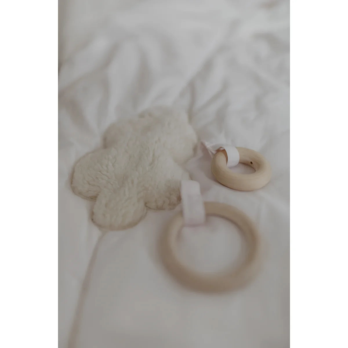 Weiches weißes wolkenförmiges beißspielzeug mit zwei natürlichen holzringen für ökologische baby- & kinderprodukte