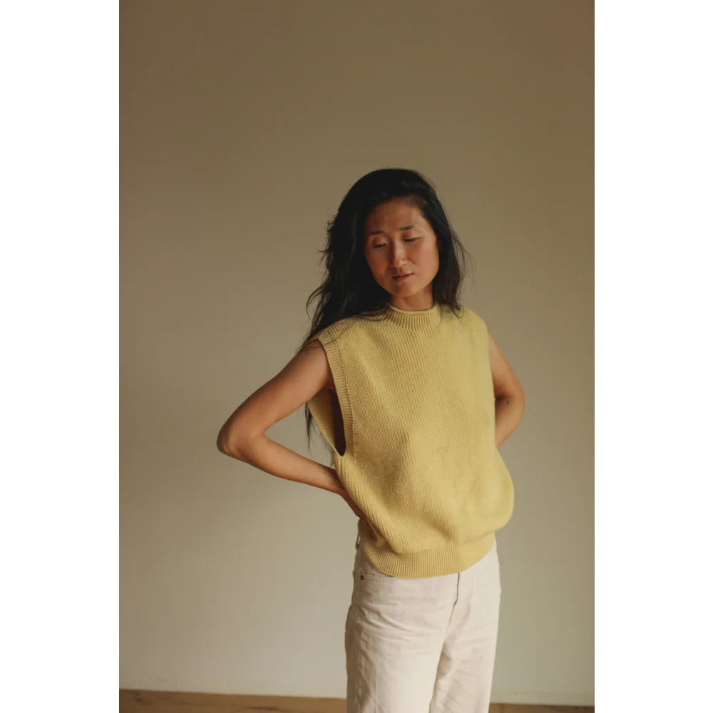 Frau trägt Pastellgelbes ärmelloses Stricktop und helle Hosen im Produkt Adult Vest Helle
