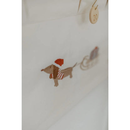 Gestickter festlicher Dackel mit Santa-Hut und Streifenschal zieht Schlitten