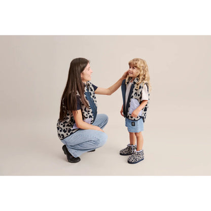 Ein kind trägt albi pile boot leo mist mit leopardmuster und passendem weste- und denim-shorts-look