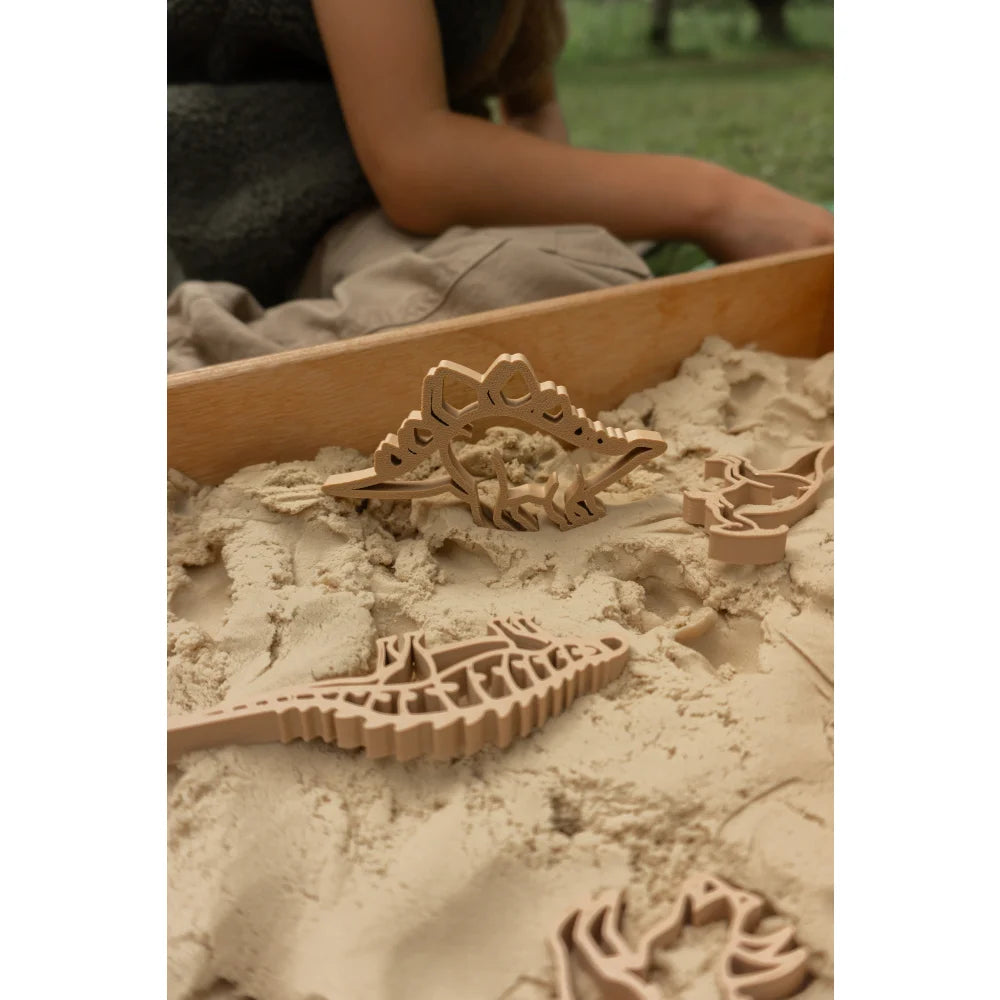 Holz-Dinosaurier-Skelett-Puzzle im Sand mit biologisch abbaubarem Kunststoff und grünem Dino-Ausstecher