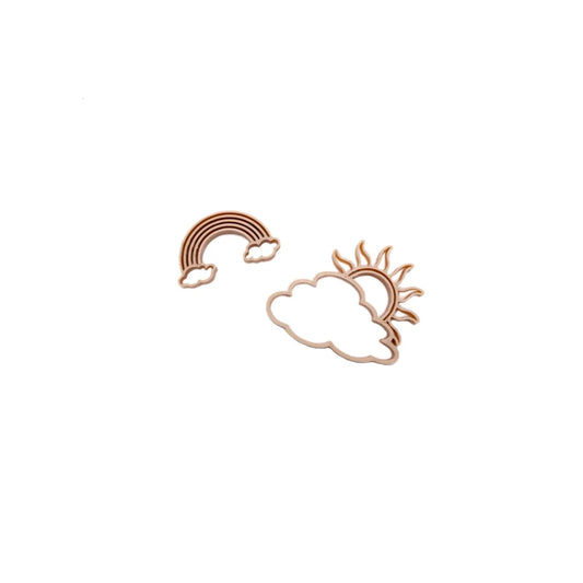 Kupferfarbene metalldaumenschneider in regenbogenform mit sonne hinter wolke ausstecher sonne und regenbogen
