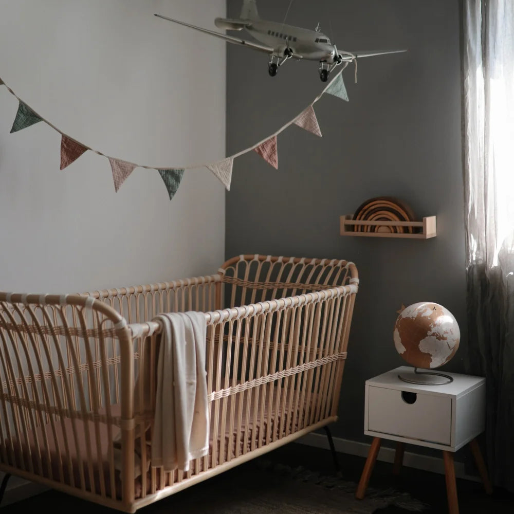 Holz-Kinderbett mit geschwungenen Latten in einem eleganten Babyzimmer von Baby Girlande