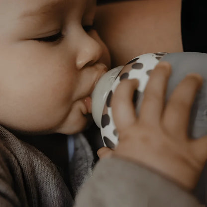 Baby trinkt aus Graouu Babyflasche 150 ml oder 240 ml mit weißen Punkten