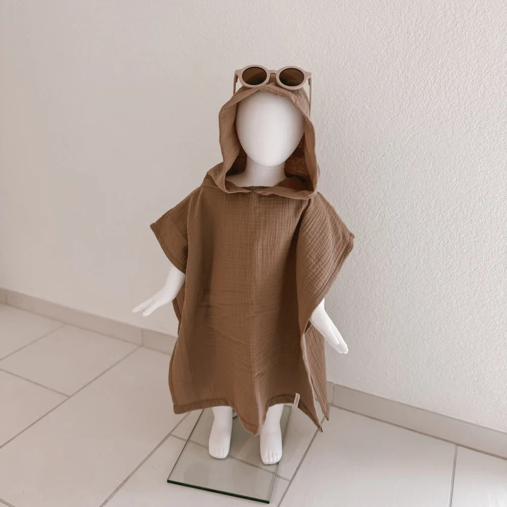 Beige Kapuzenponcho auf Kinder-Mannequin mit Sonnenbrille, Badeponcho Musselin