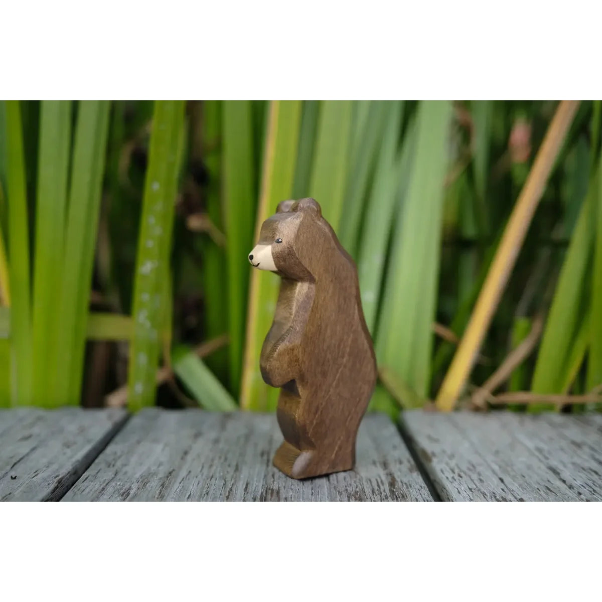 Kleiner stehender Bär aus glattem braunem Holz mit Beige-Schnauze und schwarzen Perlenaugen