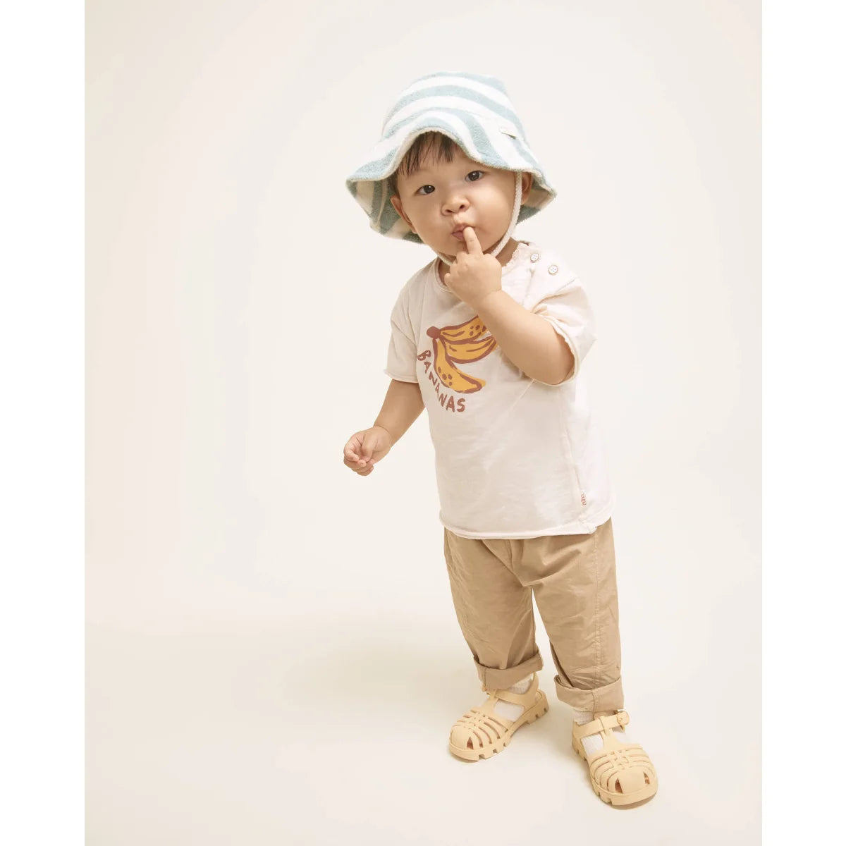 Baby mit hellblau-weiß gestreiftem Eimerhut, nachhaltige Babykleidung Schweiz