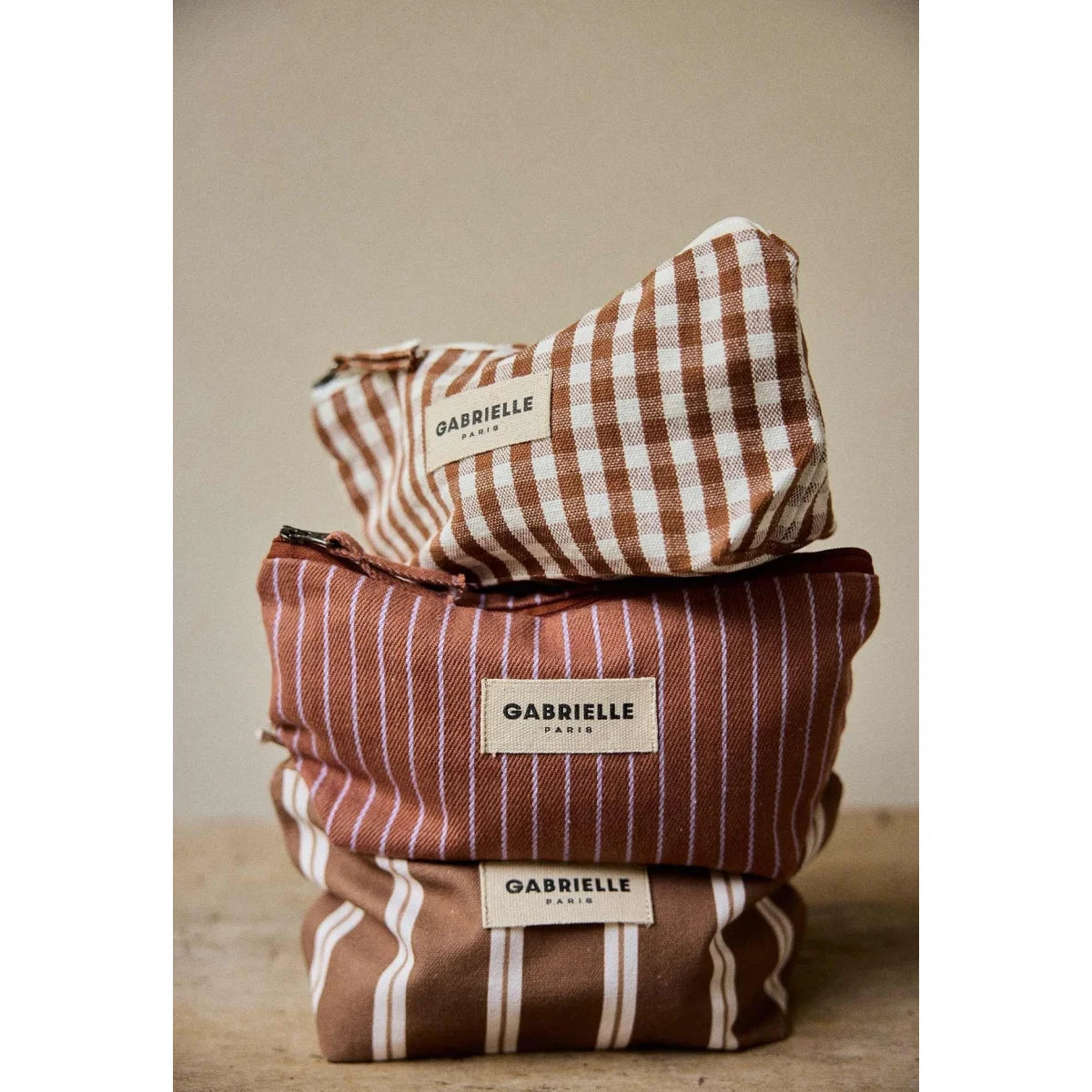 Gestapelter gabrielles paris beauty pouch stripes noisette mit braunem und elfenbeinfarbenem kariertem und gestreiftem muster ideal für ökologische baby- & kinderprodukte
