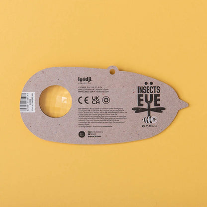 Graues Insekt-Auge-Spielzeug aus recyceltem Karton mit gelber Linse und Libellendesign