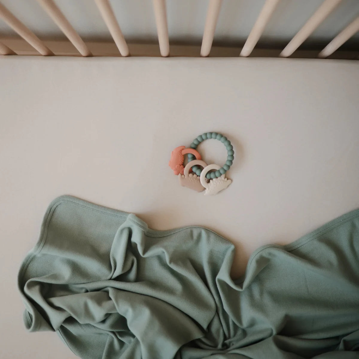 Pastellgrüner und -rosa Beissring Dino aus Silikon mit Perlenmuster