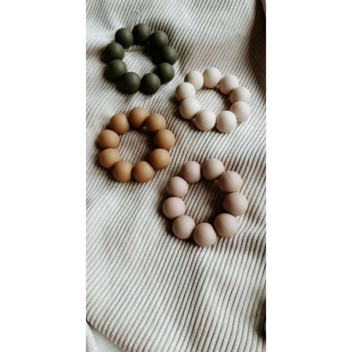 Vier Beissring Freezer Teether in Erdtönen auf Textil