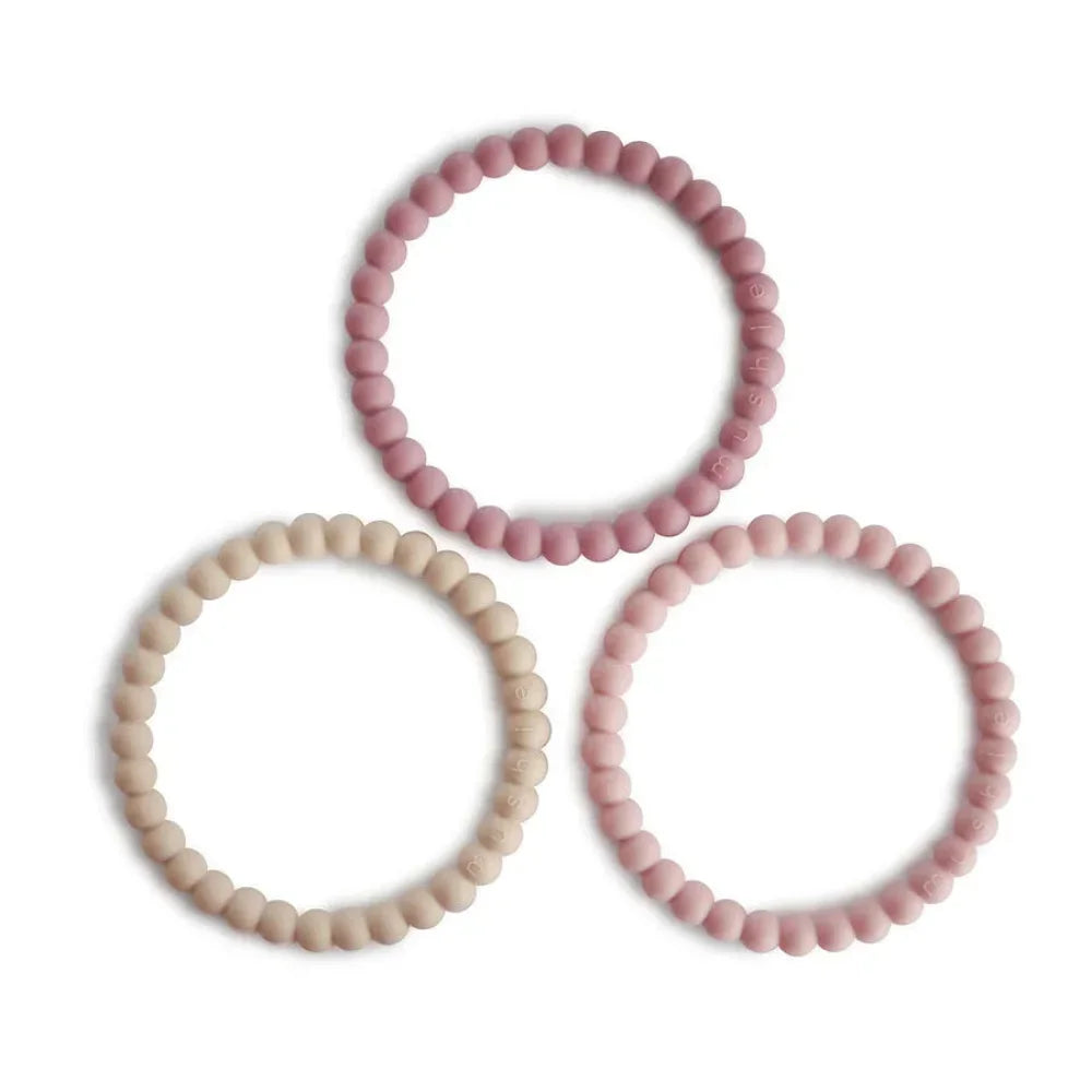 Drei Pastellarmbänder in Rosa und Beige in dreieckiger Anordnung