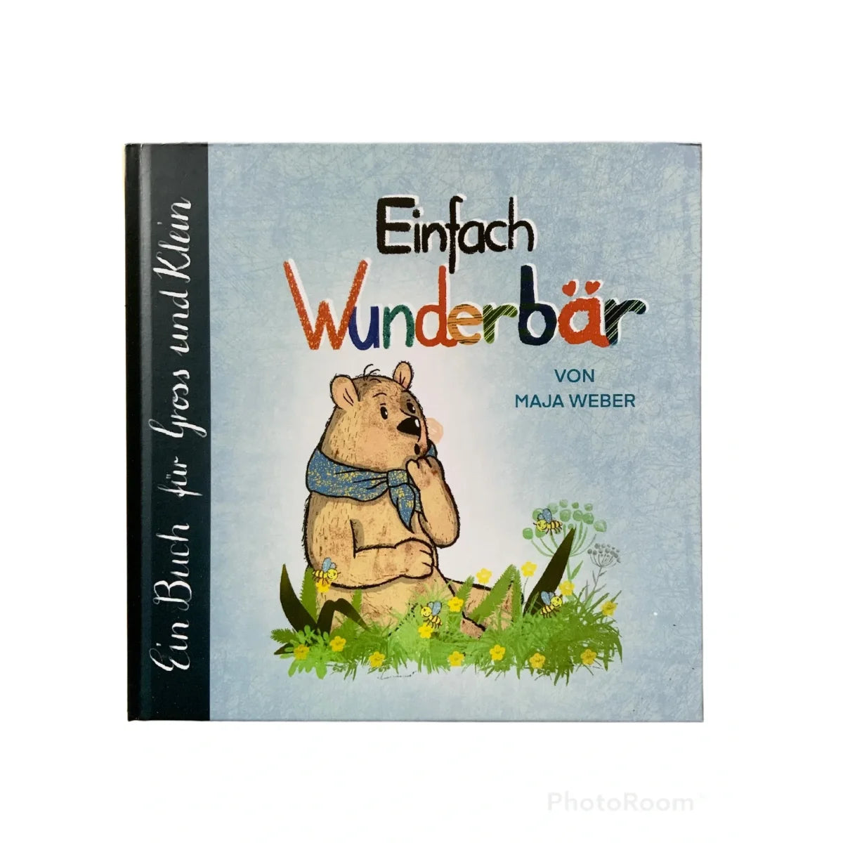 Bilderbuchcover mit einem braunen Bären im blauen Schal im Gras sitzend