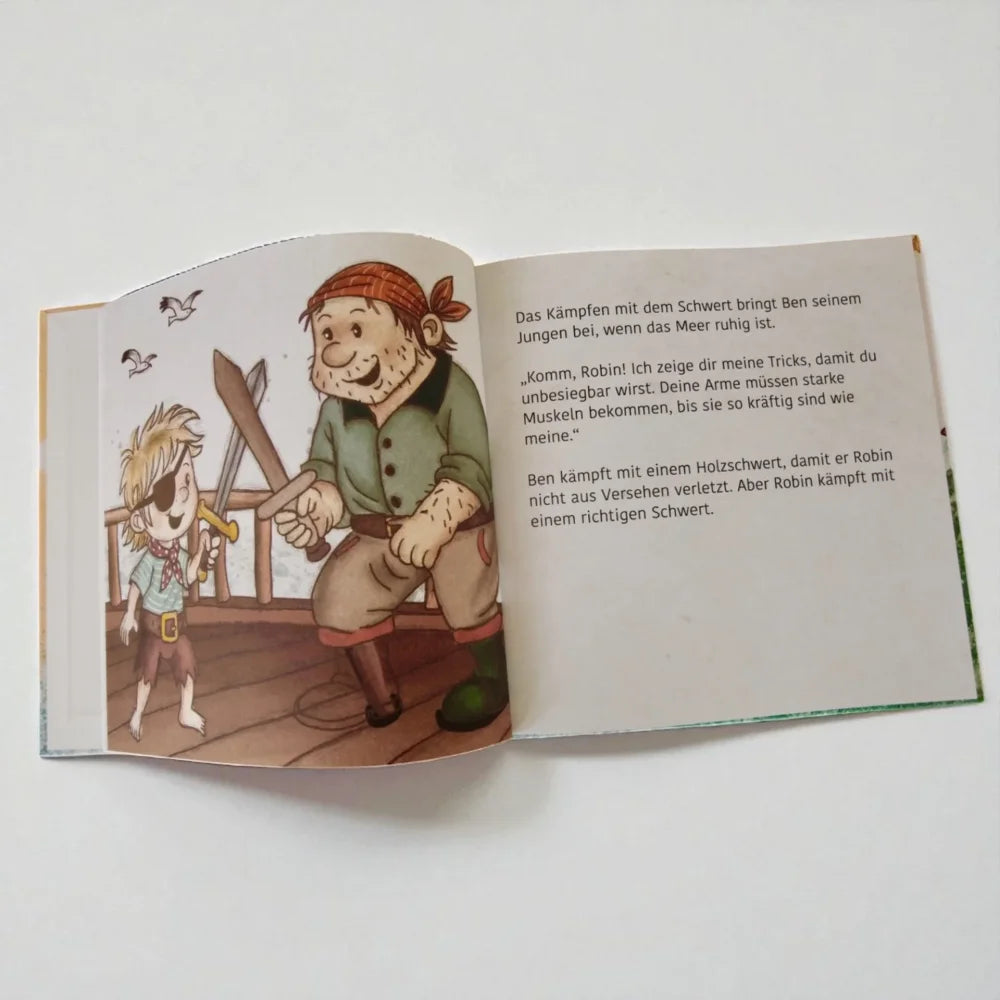 Offenes Kinderbilderbuch mit Piratenillustrationen und deutschem Text im Produkt Im eigenen Bett schlafen Robin kann das