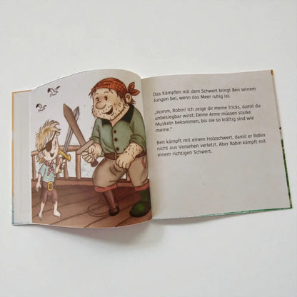 Offenes Kinderbilderbuch mit Piratenillustrationen und deutschem Text im Produkt Im eigenen Bett schlafen Robin kann das