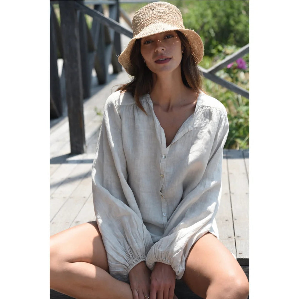 Frau trägt Strohhut und helles Leinenhemd, Produkt Bluse Lily Moon