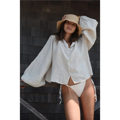 Frau trägt Bluse Lily Moon mit Strohhut und weißen Bikini-Hotpants