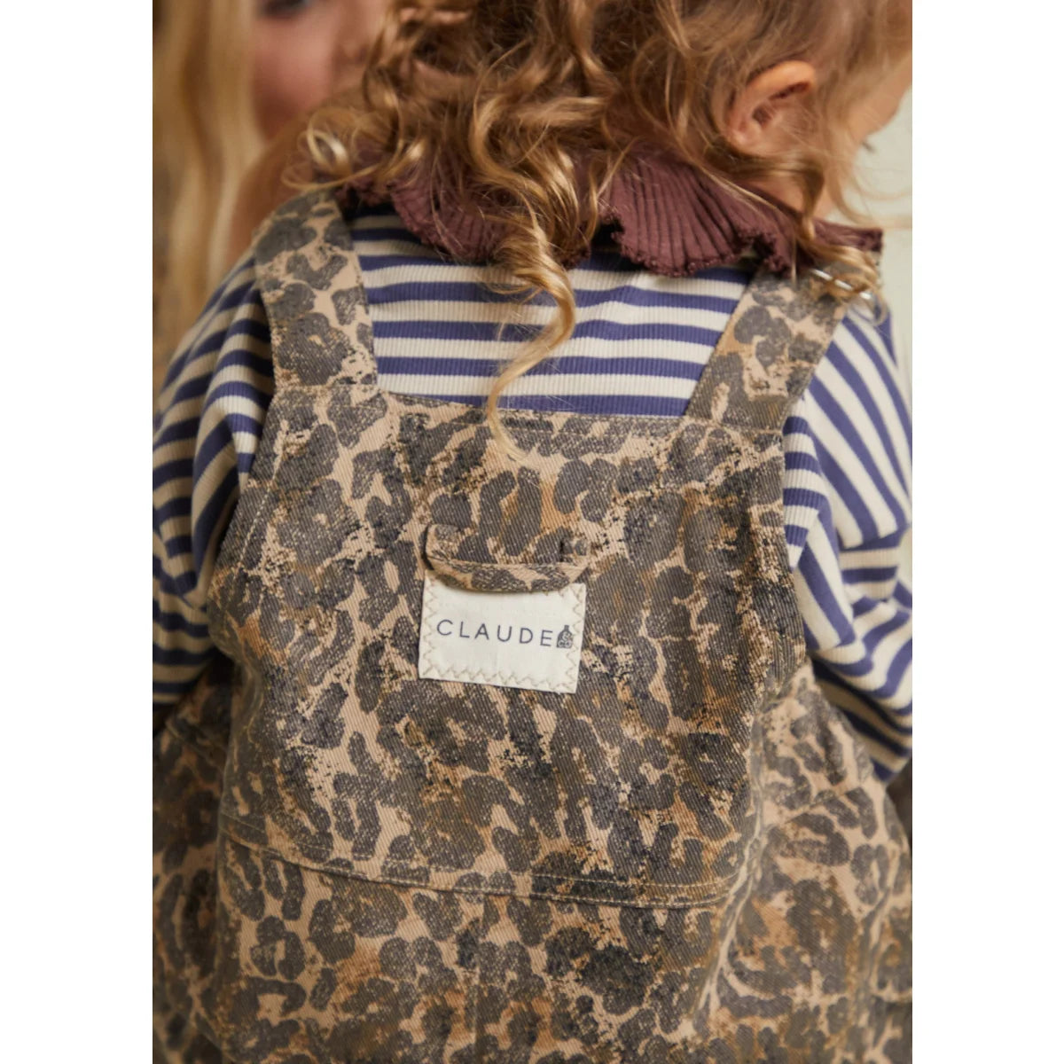 Leopardenmuster-Jeanslatzhose mit einem ’claude’ Markenlabel auf dem Rücken.