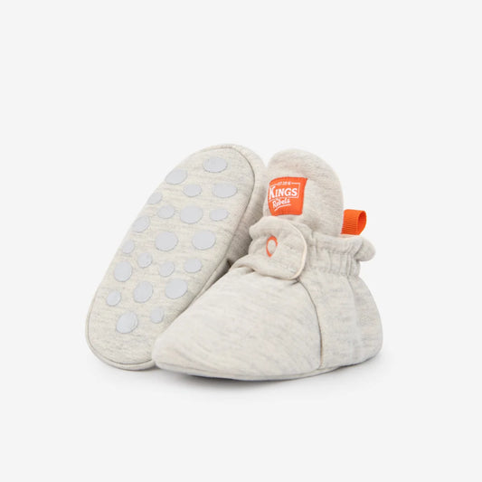 Weiche graue babybooties mit orangefarbenem branding und rutschfester sohle aus nachhaltiger babykleidung schweiz