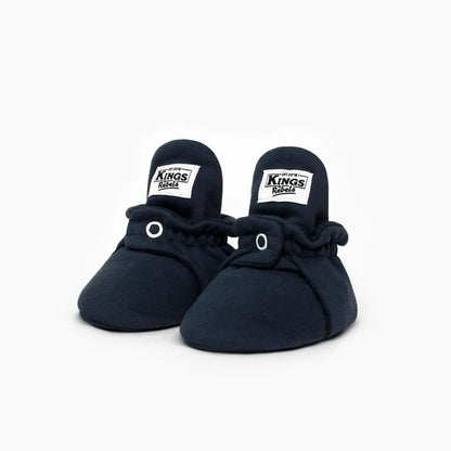 Navy blaue babybooties aus weicher baumwolle mit elastischem bund und weißen labels nachhaltige babykleidung schweiz