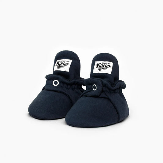 Navy blaue babybooties aus weicher baumwolle mit elastischem bund und weißen labels nachhaltige babykleidung schweiz