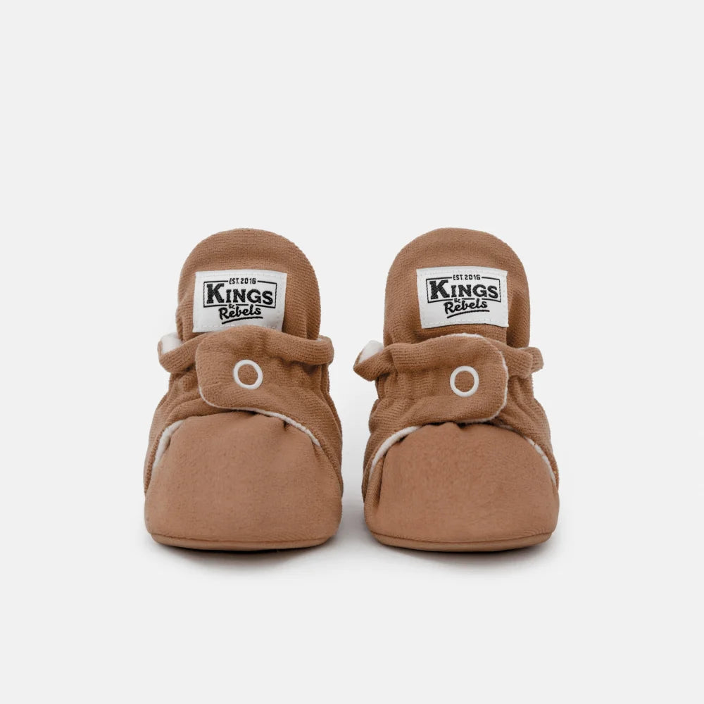 Paare von hellbraunen Babysöckchen mit weißen Druckknöpfen für das Produkt Booties Gamuza Classic 0-12 Monate Mocha