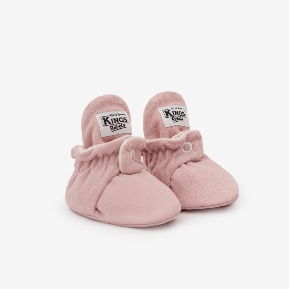Paar rosa Babybooties mit weißen Labels an den Innenseiten der Bündchen