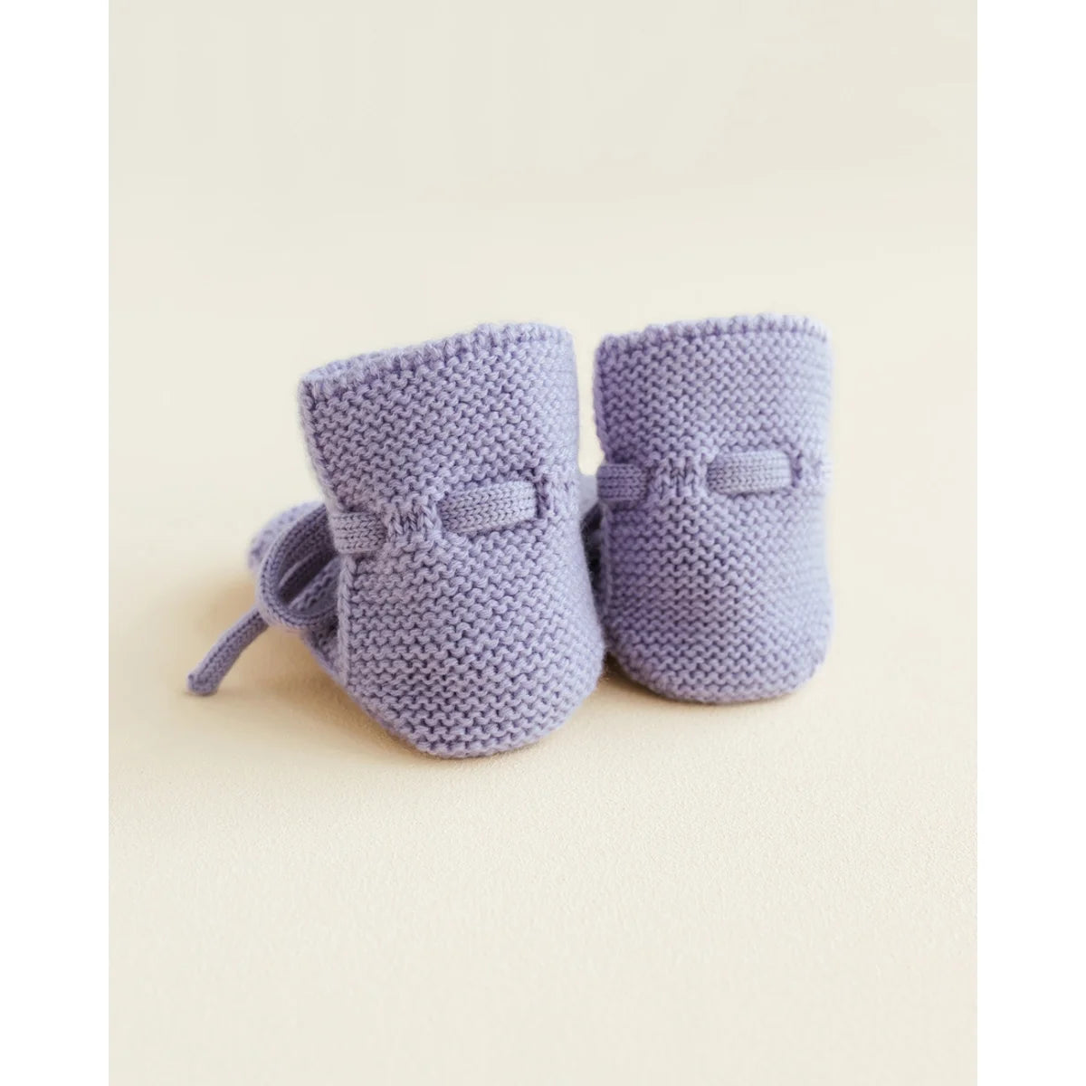 Lila Babyschuhe aus Merinowolle von oben fotografiert