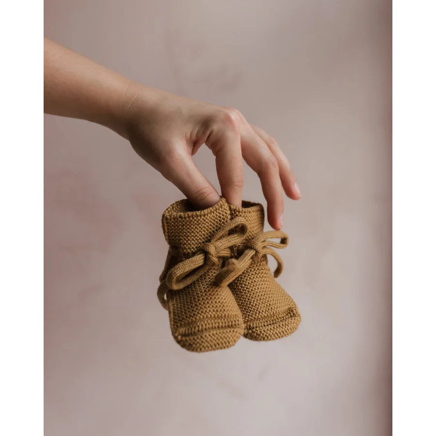 Paar gestrickte oder gehäkelte Babybooties in hellbrauner Farbe, Modell Ochre