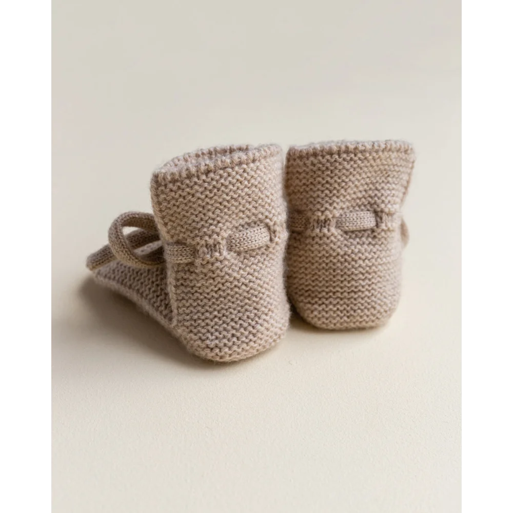 Beige gestrickte Babybooties mit kleinen Schleifen im Produktname Booties Sand