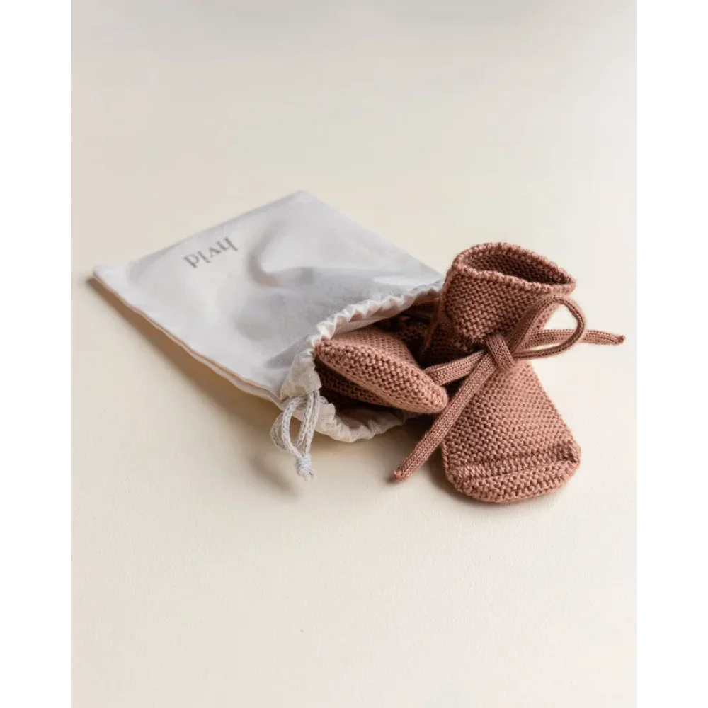 Paar handgestrickte Babybooties in staubrosa für ökologische Kinderbekleidung