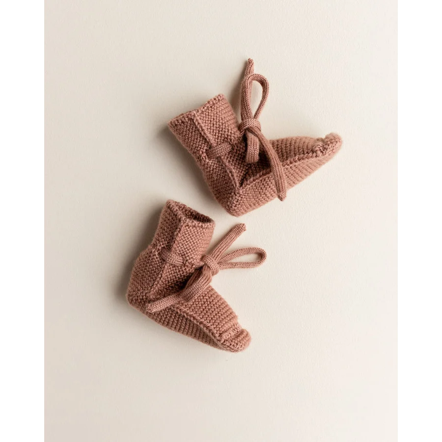 Paar rosa Strick-Babyschuhe mit Bändern, umweltfreundliche Babyartikel für ökologische Kinderbekleidung